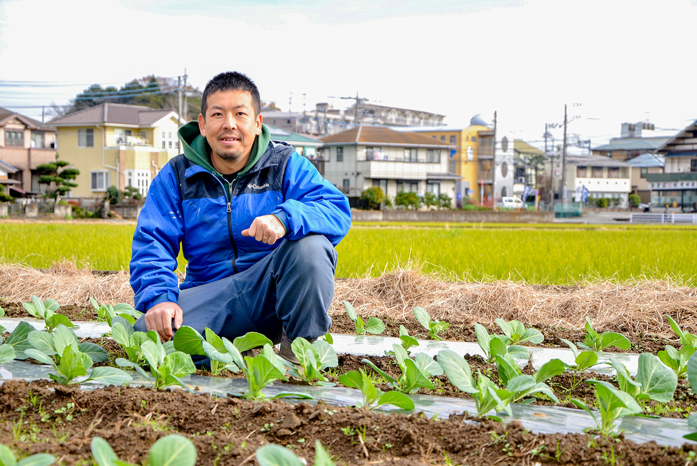 圃場に座ってこちらを見ている髙橋さんの写真