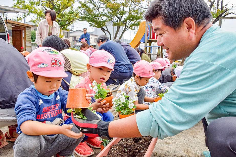 子供と花を植えている写真