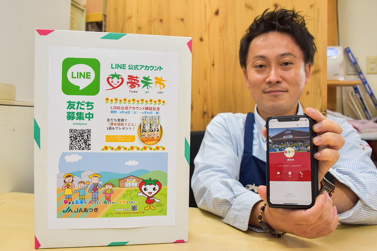 夢未市のLINE公式アカウントをPRする清田店長の写真