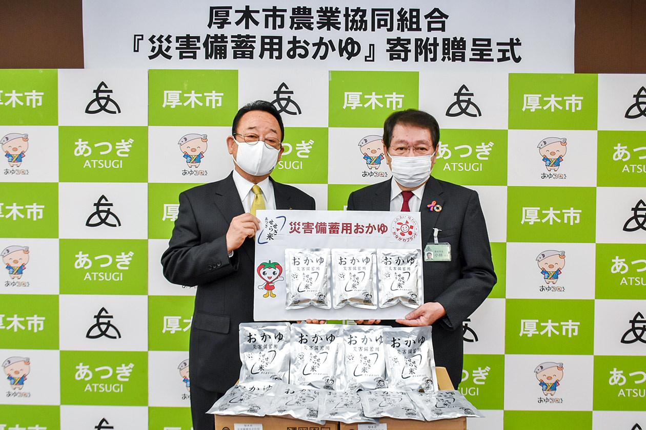 小林市長（右）に災害備蓄用おかゆを寄贈する大貫組合長（左）の写真