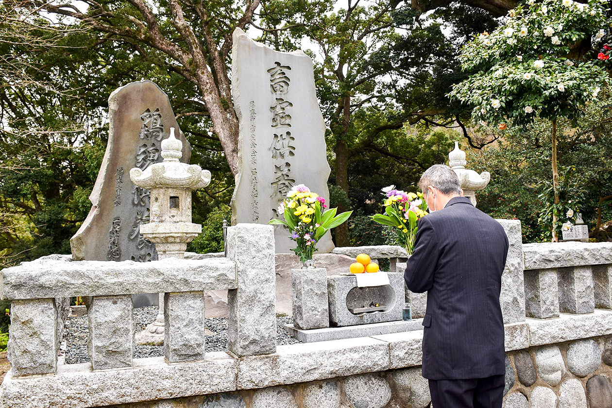 畜霊供養碑に手を合わせる会員の写真