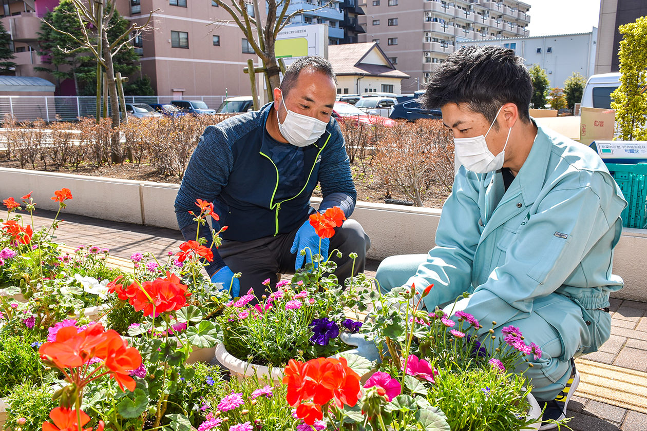 寄せ植えを制作する部会員とJA職員の写真