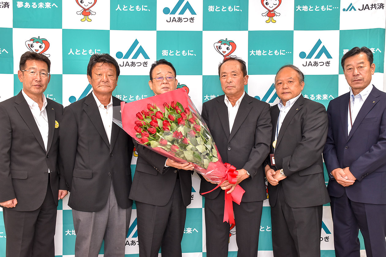 大貫組合長（左から3人目）にバラを贈る部会代表者の写真