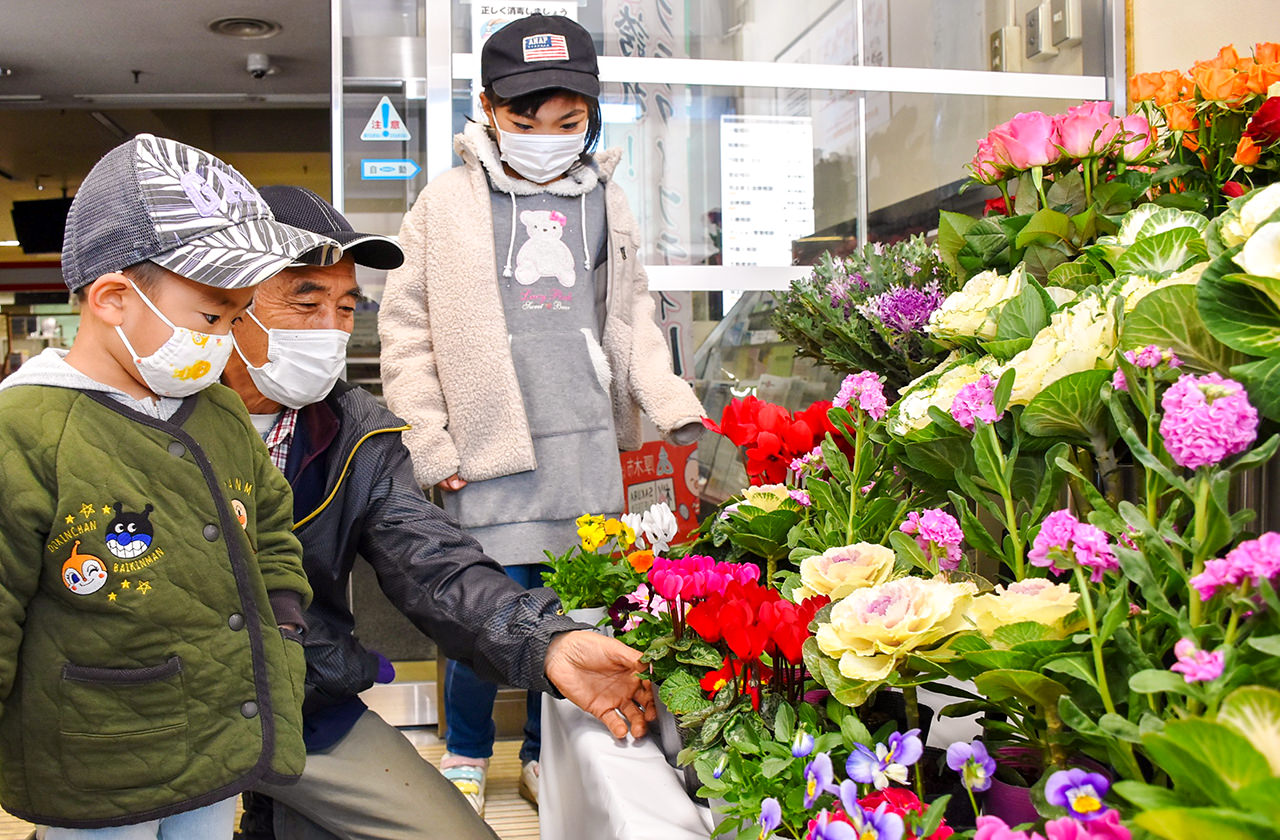 見学する子どもに花の特徴を説明する難波部会長の写真