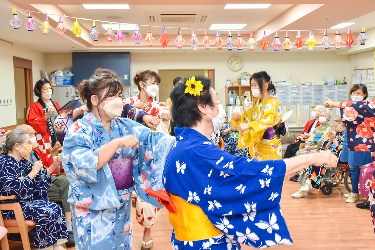 利用者と盆踊りを踊るメンバーの写真