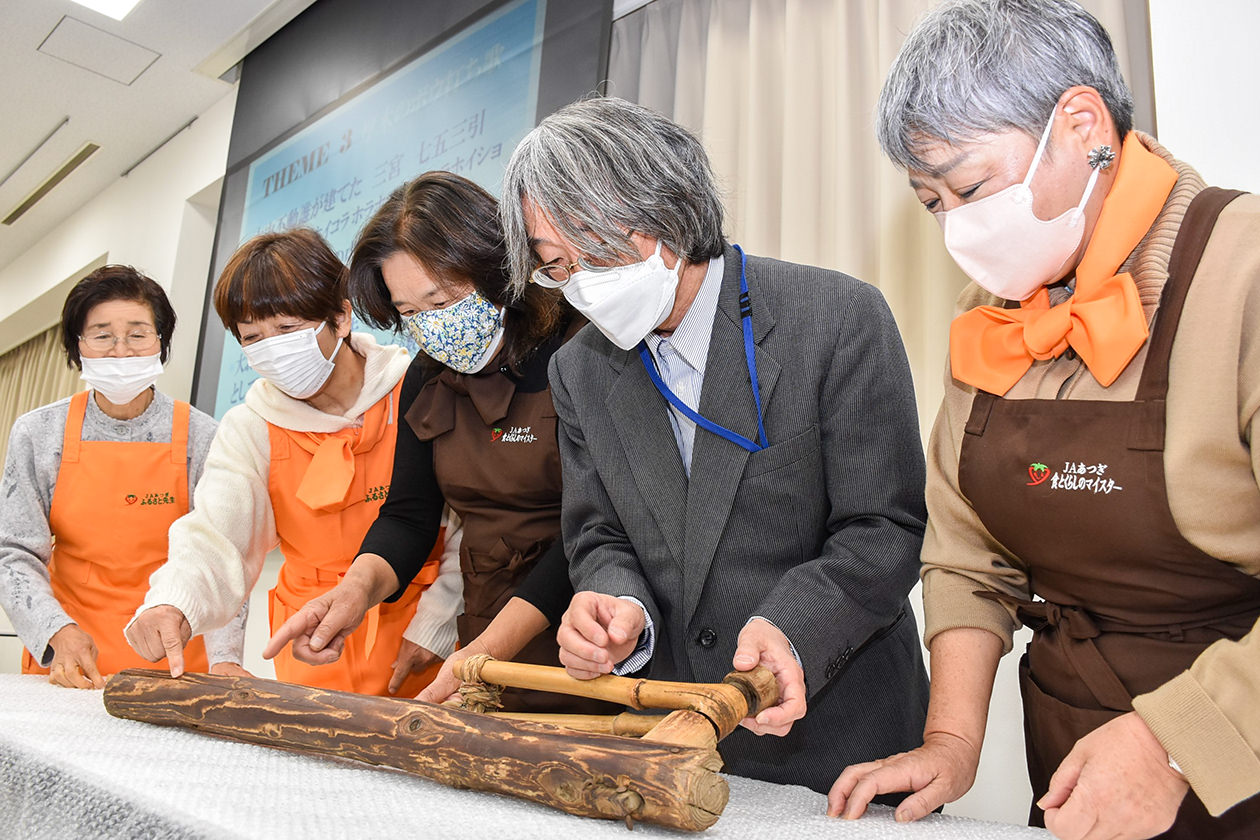 学芸員からクルリ棒の特徴を学ぶ様子の写真