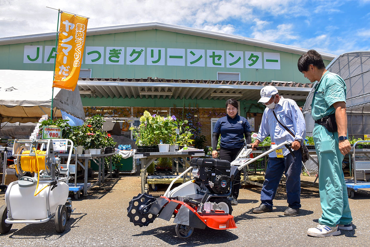 農業機械の特徴や使用方法を学ぶ来場者の写真