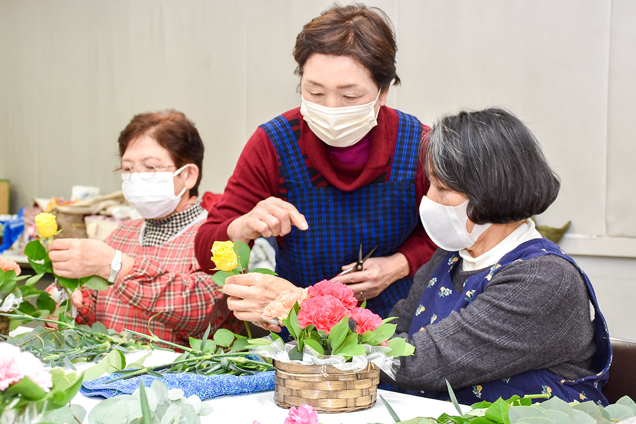 講師（中）から配置のポイントを学ぶ参加者の写真