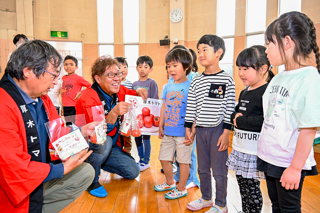 子どもたちに「厚木トマト」の魅力を伝える部会員の写真