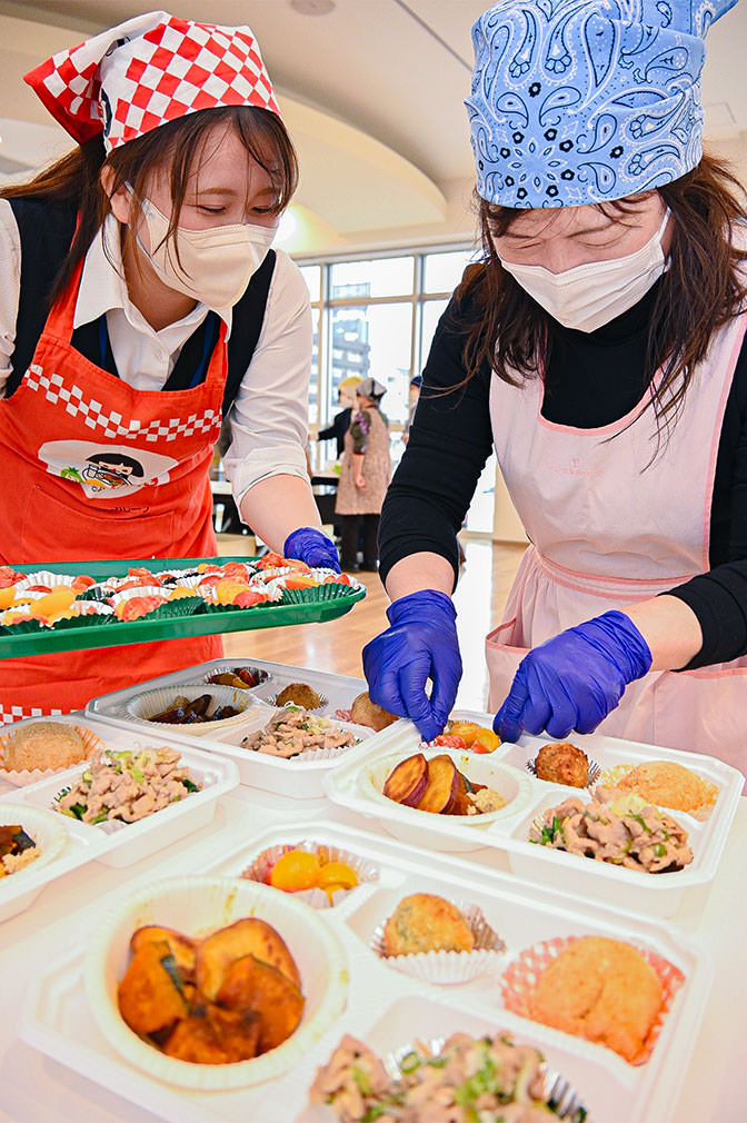 料理を盛り付ける部員とJA職員の写真