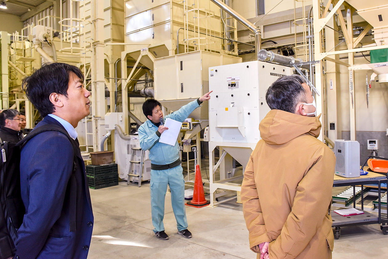 JA職員からライスセンターの説明を受ける議員らの写真