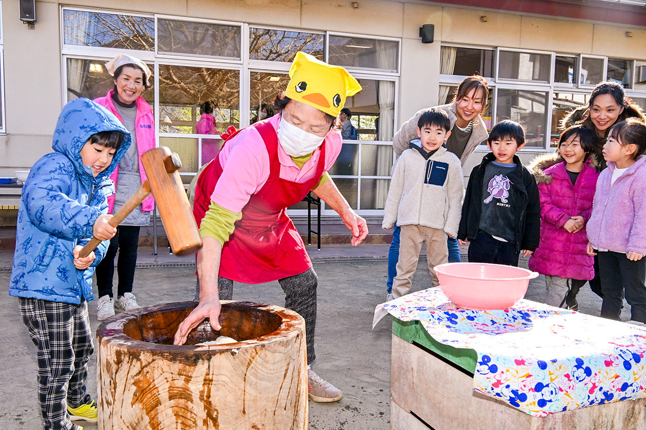 隊員と共に餅つきを楽しむ園児らの写真