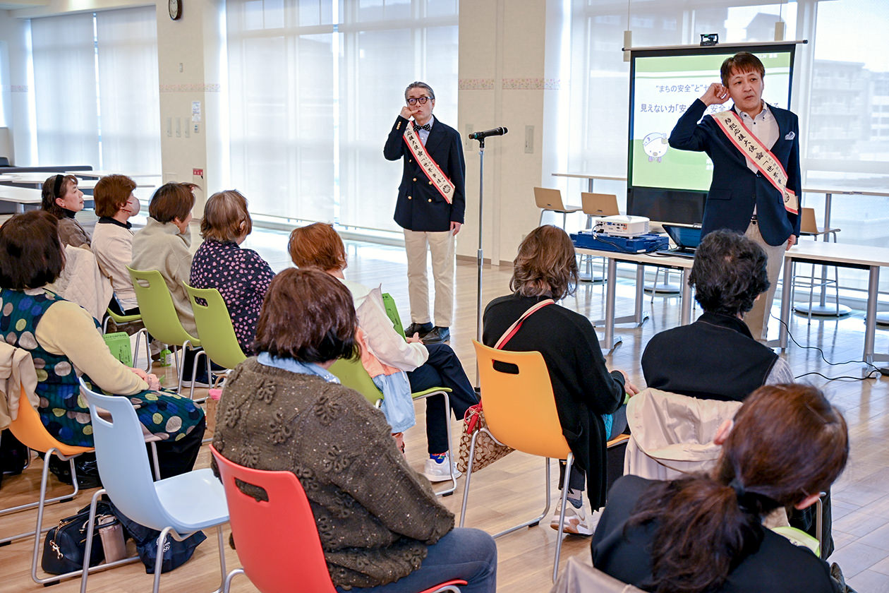 漫才を交えた詐欺手口の実演に耳を傾ける会員の写真