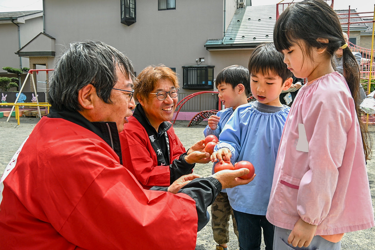 保育園児に「厚木トマト」の魅力を伝える部会員の写真