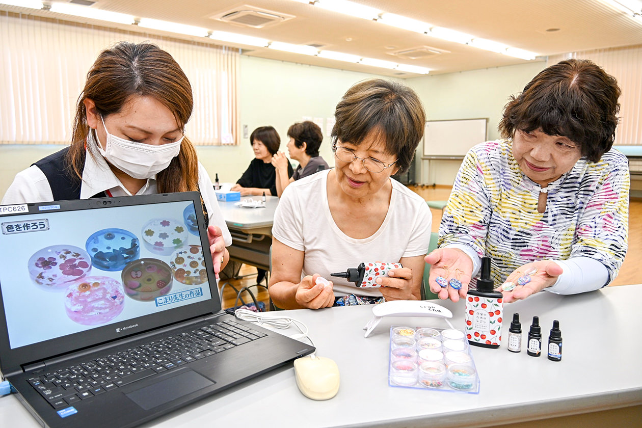 動画に沿って型にレジン液を流す参加者（中）の写真
