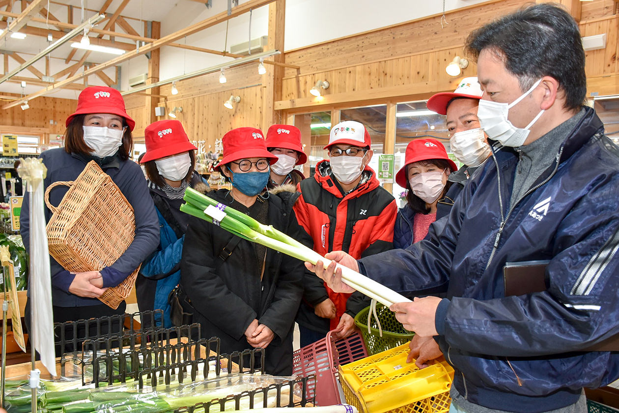 JA職員（左）と出荷時の注意点を確認する修了生の写真