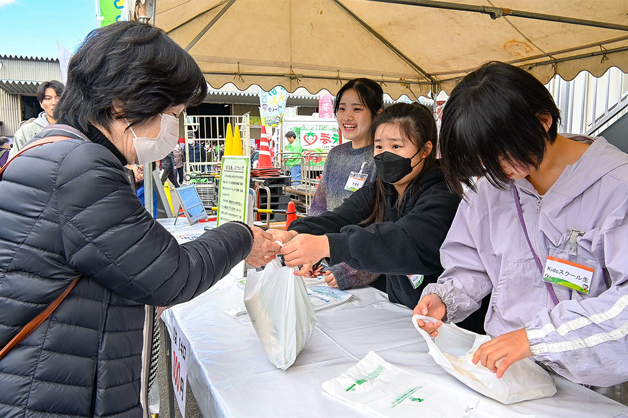 農業まつりで育てたもち米を販売するスクール生の写真